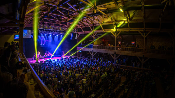 Wide view of a live concert crowd inside Penn’s Peak in Jim Thorpe, with stage lighting beams over a packed audience during an indoor live music performance.