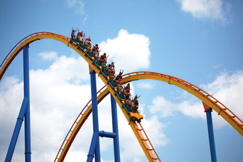 A wide view of people on a yellow and blue roller coaster at Hersheypark in Hershey, Pa.
