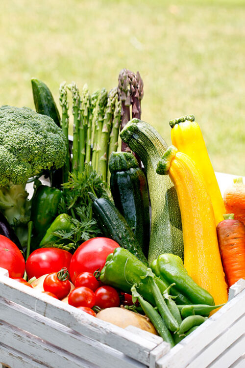 A wooden box full of tomatoes, peppers, asparagus, broccoli and more at the Abington Farmers Market in South Abington Twp., PA.