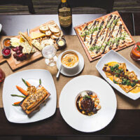 An assortment of fresh, farm-to-table dishes and beverages, characteristic of the seasonal menu offered at Harvest Seasonal Grill & Wine Bar, farm to table restaurant in Moosic, PA.