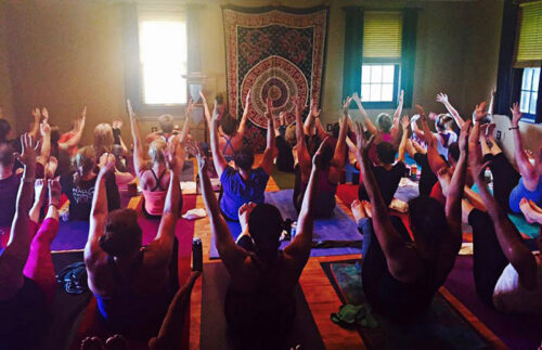 A class collectively holds a yoga pose at Peace of Mind Yoga Studio in Sugarloaf, PA.