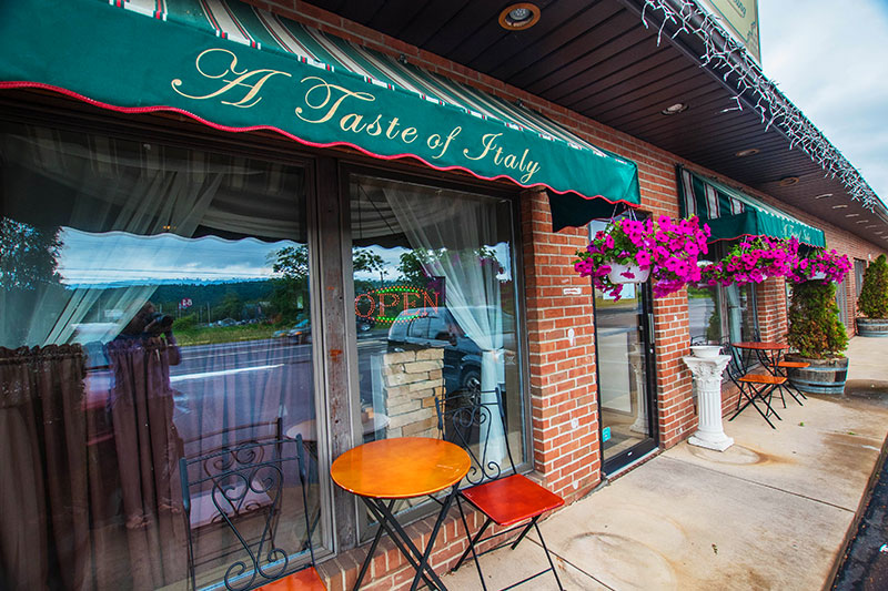 Exterior shot of awning and sidewalk seating at A Taste of Italy in Bloomsburg, PA.