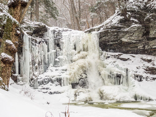 Ice spills over the edge of a frozen waterfall along the falls trail at Ricketts Glen State Park in Benton, PA.