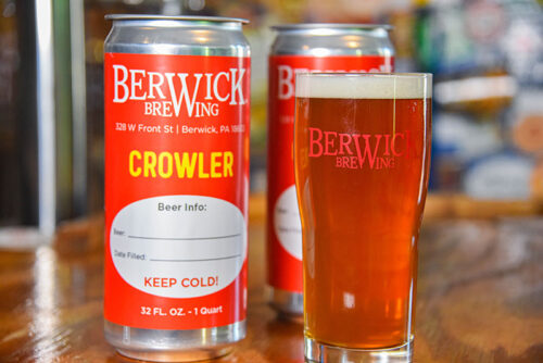 A crowler (to-go) can and a pint of beer on the bar at Berwick Brewing Company in Berwick, PA.