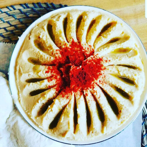 A dish of creamy hummus topped with paprika and olive oil served at The Garden Mediterranean Café and Grill in Scranton, PA.