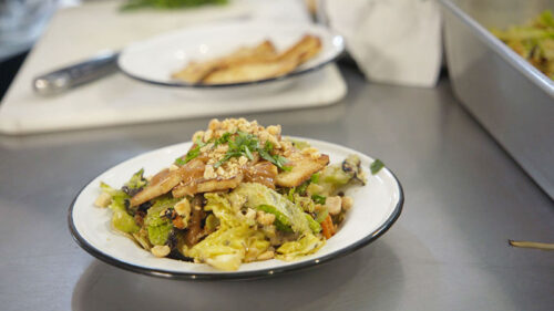 A savory tofu and vegetable dish garnished with peanuts and herbs, prepared at NutMeg Market in Forty Fort, PA.