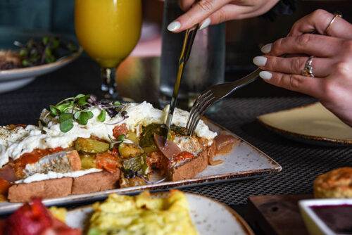 A woman slicing an egg and vegetable dish from The Settlers Inn in Hawley, PA.