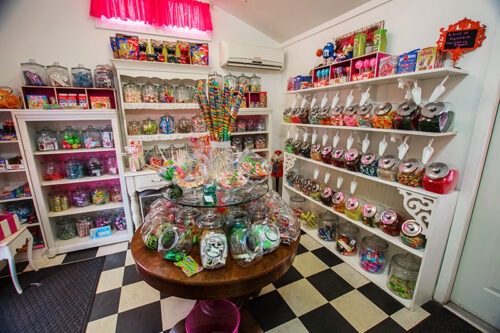 Walls lined with shelves and a wooden table display old-fashioned glass jars at Ebb’s Candy Jar in Tunkhannock, PA.