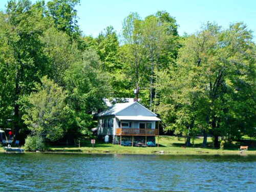 The exterior of a rental home from across the water at Keen Lake Camping Resort in Waymart, PA.
