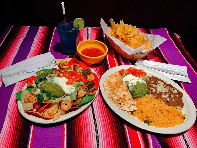 Two entrees, chips and salsa displayed on a colorful table cloth at Playa Cancun in Bloomsburg, PA.