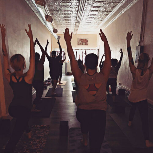 A group of people hold a pose during a yoga class at Yoga West in Mayfield, PA.