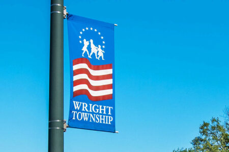 A flag on a streetlight pole depicting an american flag. Text reads: 
