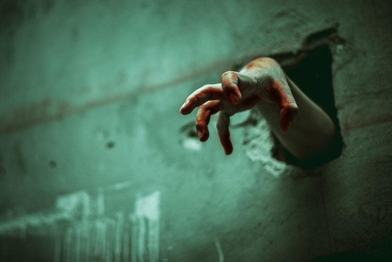 Hand reaching out through the wall at Horror Hall a haunted house in Nanticoke, PA.