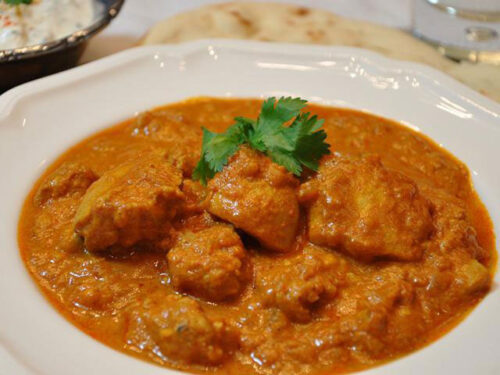 A plate of orange colored tikka masala from New Amber Indian Restaurant in Moosic, PA.