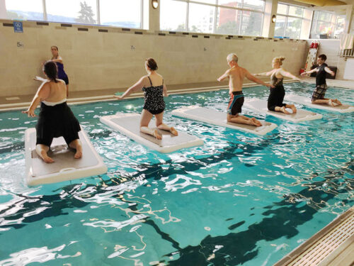 A row of women doing paddle board exercises at the Jewish Community Center of Scranton in Scranton, PA.
