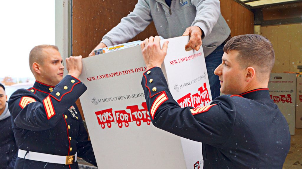 Two Marines lift a Toys for Tots donation box from a truck during collection efforts in Wyoming, PA.