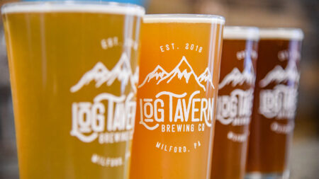 Four beers in pint glasses lined up on the bar at Log tavern brewing Co. in Milford, PA.