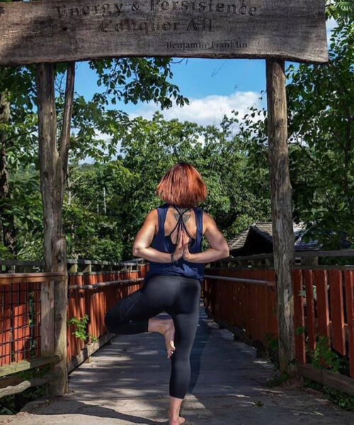 A woman holds a yoga pose in an outdoor pavilion at Quest Studio in Jessup, PA.