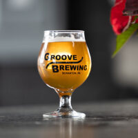 A cold beer in a snifter glass on the bar at Groove Brewing in Scranton, PA.