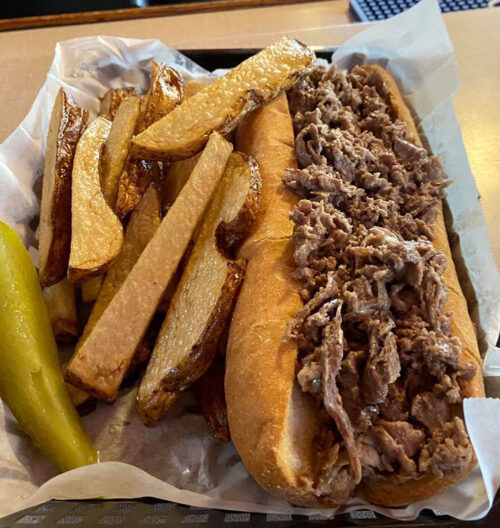A cheesesteak with a generous helping of steak and a side of fries and a pickle from the Lighthouse Inn in West Wyoming, PA.