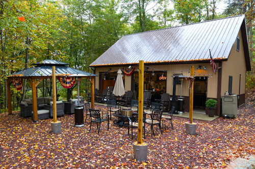 A view of the outdoor patio area featuring a small gazebo, wicker chairs and a firepit at Half Barrel Brewing Company in Lehighton, PA.
