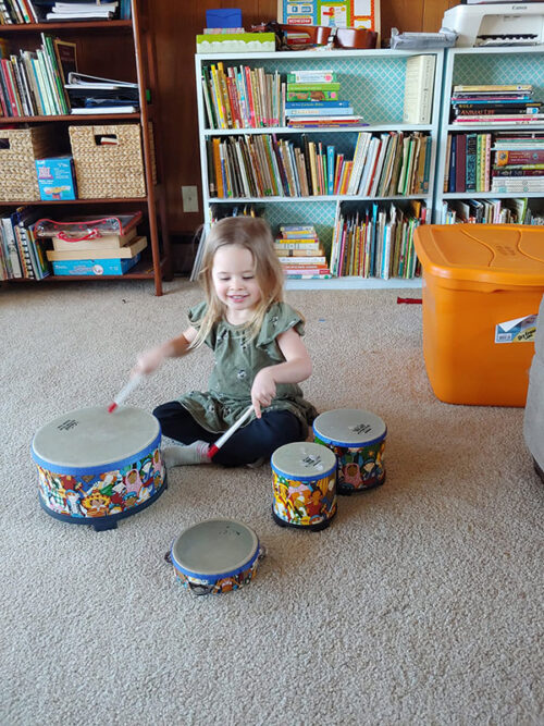 A little girl playing instruments on the floor at Music Together of the Abingtons in Waverly, PA.