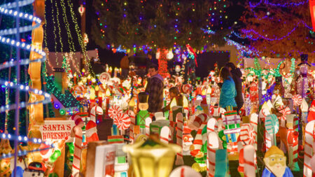 Family walking through holiday light display at the Peckville Christmas House in Peckville, PA.