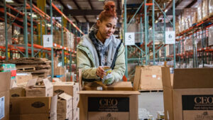 A volunteer packs a box with canned goods inside the CEO/Weinberg Northeast Regional Food Bank warehouse in Pittston, PA.