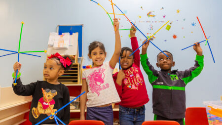 Preschoolers at the Wyoming Valley Catholic Youth Center in Wilkes-Barre, PA proudly hold up colorful building sticks in their classroom.