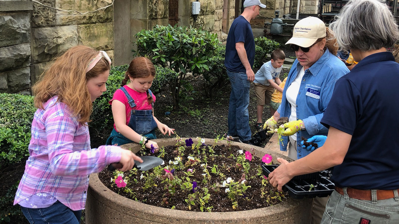 A group of volunteers helps fill a large planter with flowers in Downtown Scranton.