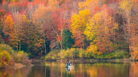 A fisherman on a boat casts his line into Lackawanna Lake inside Lackawanna State Park in North Abington Twp., PA.