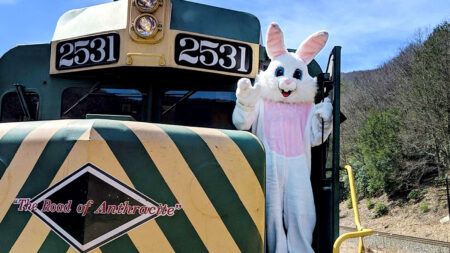 The Easter bunny stands on the platform of the Lehigh Gorge Scenic Railway locomotive, number 2531, with the words 