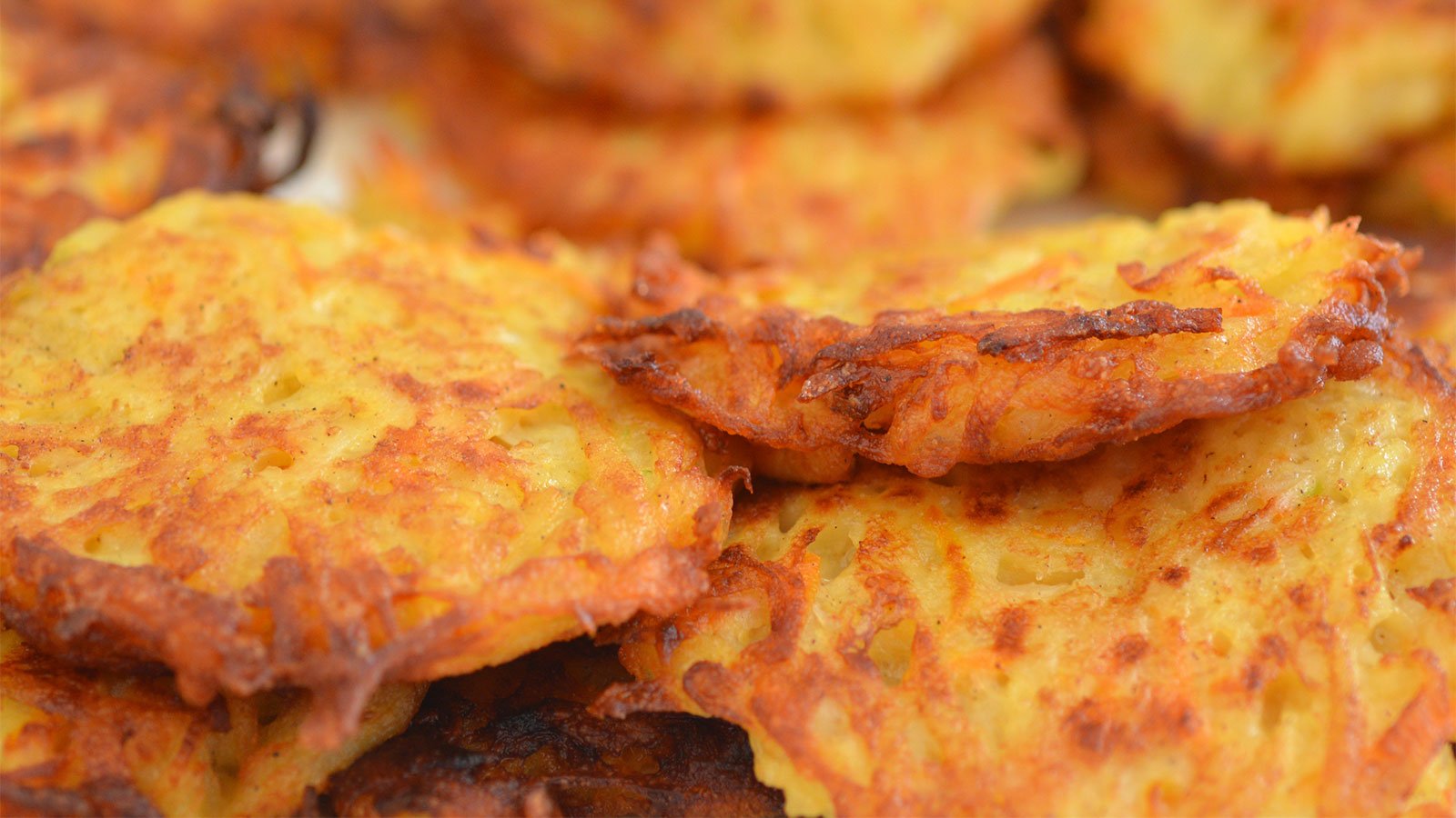 A close up look at golden, fried potato pancakes.
