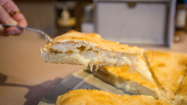 A slice of pagach being lifted off the tray at Happy Pizza in Plymoth, PA.