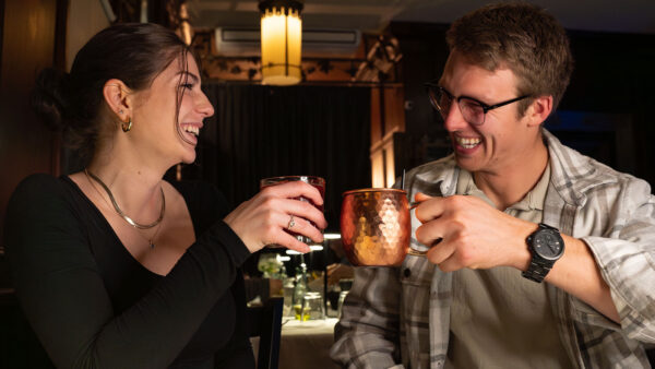 A couple cheersing their cocktails at Ravyn & Robyn, a popular date night restaurant in Hawley, PA.