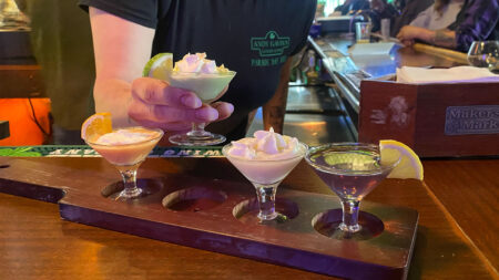 A woman's hand picking up a mini martini from a martini flight at Andy Gavin's in Scranton, PA.