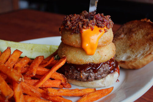 A burger with onion rings, bacon, and cheese sauce from West End Ale Haus in Bloomsburg, PA.