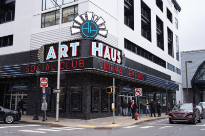 The exterior of the Scranton Art Haus in Scranton, PA. The building's facade features a black and white color scheme with neon signs that read 