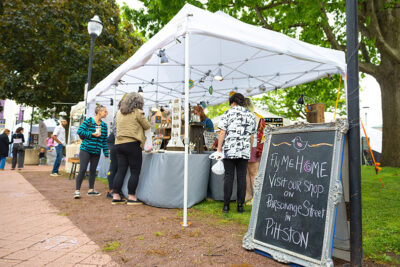 Shoppers browse the Fly Me Home artist tent at the Fine Arts Fiesta in Wilkes-Barre, PA.