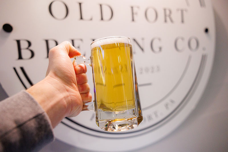 A person raises a glass of beer at Old Fort Brewing Company in Forty Fort, PA.