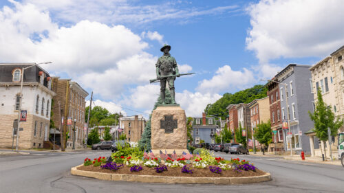 A statue memorializing veterans surrounded by flowers in the center of Pottsville, PA.