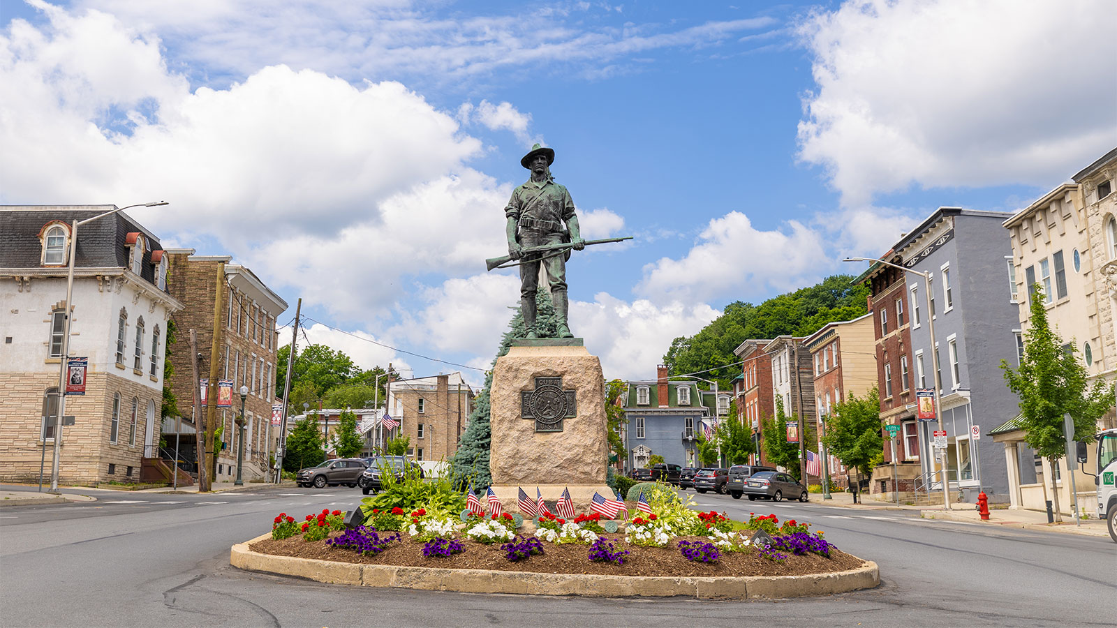 A statue memorializing veterans surrounded by flowers in the center of Pottsville, PA.