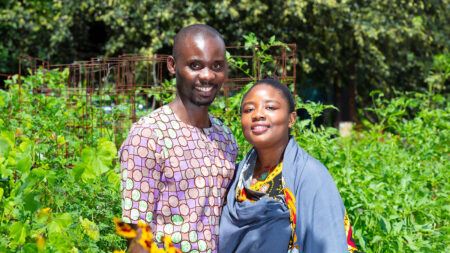 Ushu & Prisca Mukelo stand in a vibrant green garden in Scranton, PA.