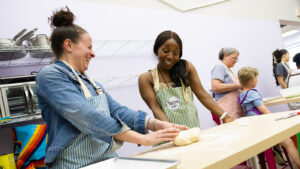 Two women participating in a cooking class at Scrumdiddly Kitchen, one of many businesses offering summer workshops and classes in NEPA.
