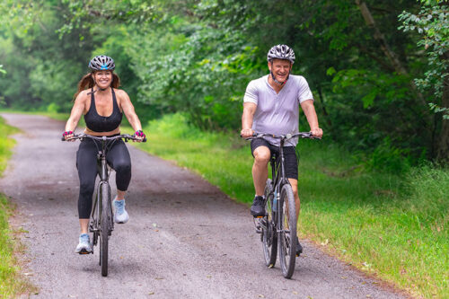 A man and woman cycling on the Lehigh Gorge Trail with Pocono Biking.