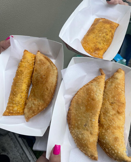 Three food boats containing fried hispanic hand-held foods like empanadas from D'Island Grill food truck in Wilkes-Barre, PA.