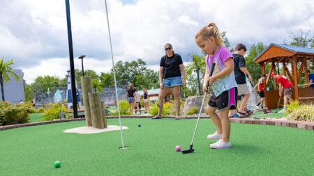 With her mom looking on, a little girl putts a pink golf ball at Malarcari's Ice Cream & Mini Golf in Mountain Top, PA.