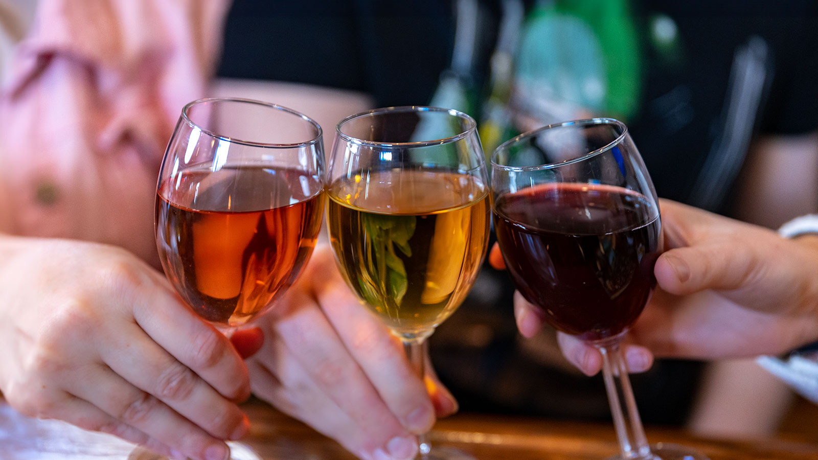 Three friends clink wine glasses with Rose', white wine and red wine at Case Quattro Winery in Peckville, PA.