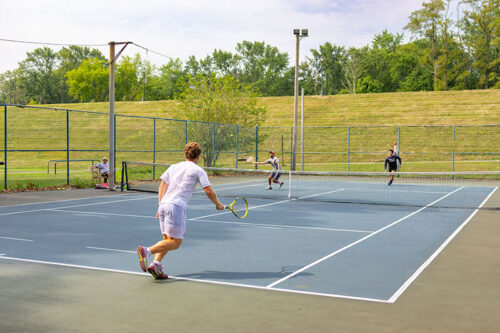 A group of young men enjoy a game of pairs tennis on the courts at Kirby Park in Wilkes-Barre, PA.
