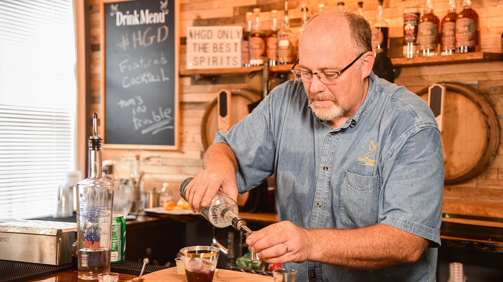 A bartender measures spirits for a cocktail before pouring and mixing at Holy Ghost Distillery in White Haven, PA.
